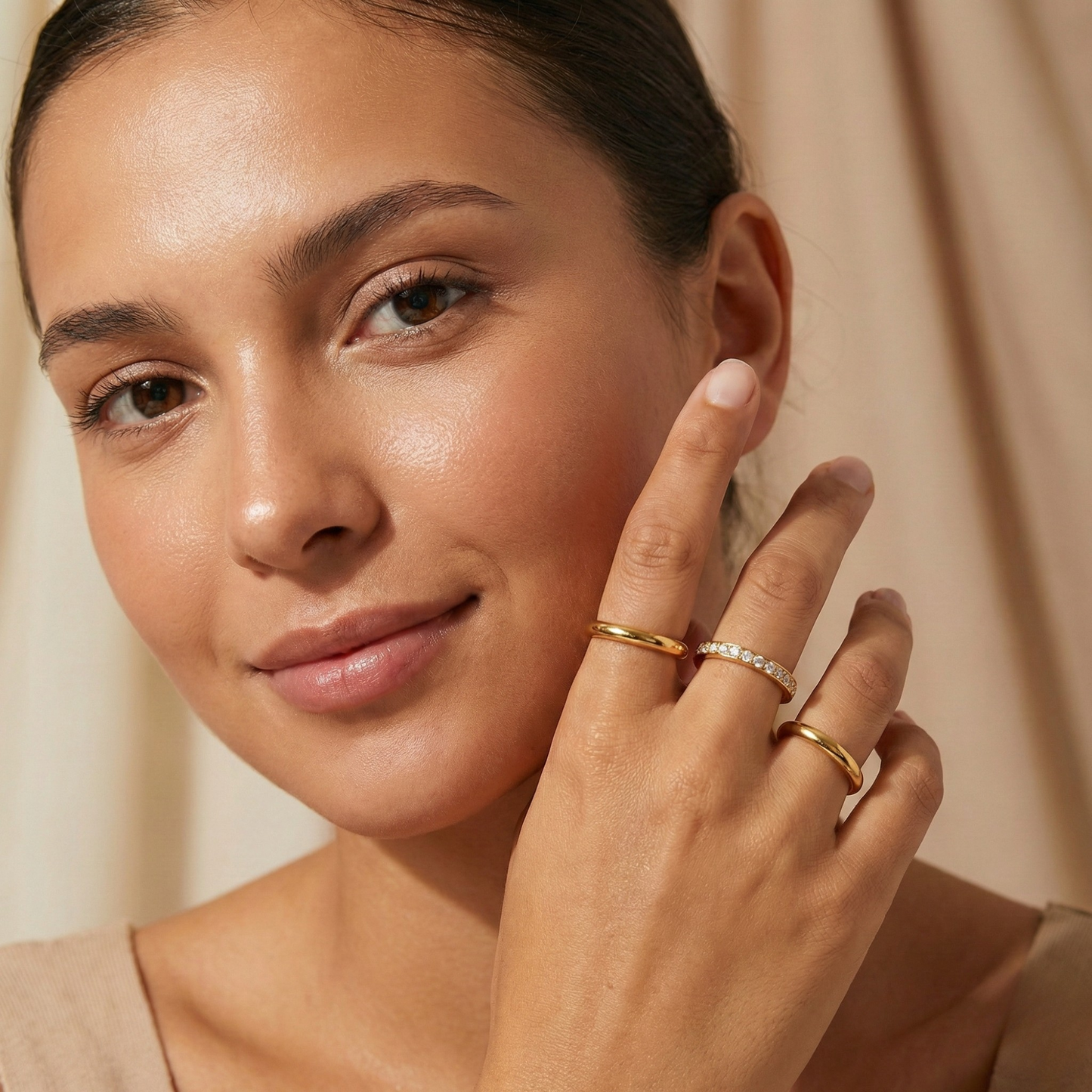 Close up of Gold Eternity Trio Stacking Ring Set by MXW Jewellery featuring a central crystal band nestled between two smooth gold bands.