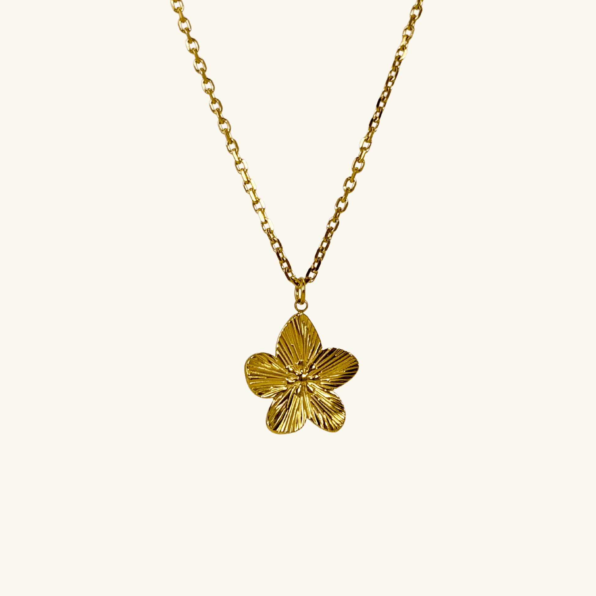 Gold flower pendant necklace on model, waterproof floral jewellery with dainty chain