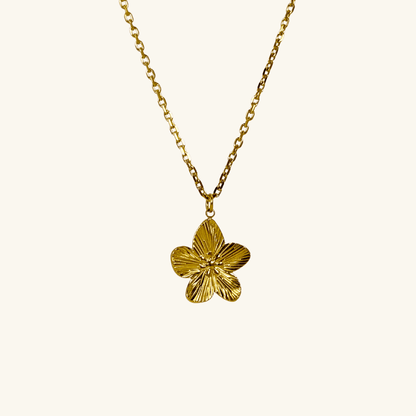 Gold flower pendant necklace on model, waterproof floral jewellery with dainty chain