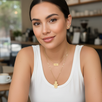 Gold Hamsa hand pendant necklace with engraved eye on a fine chain