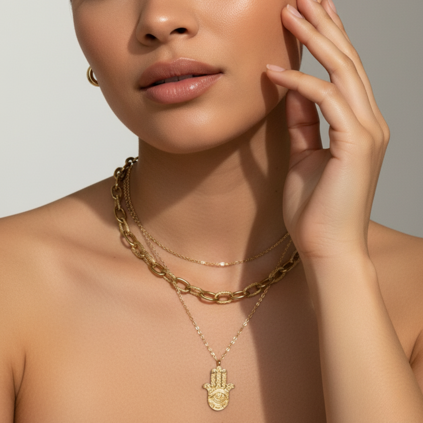 Gold Hamsa hand pendant necklace with engraved eye on a fine chain