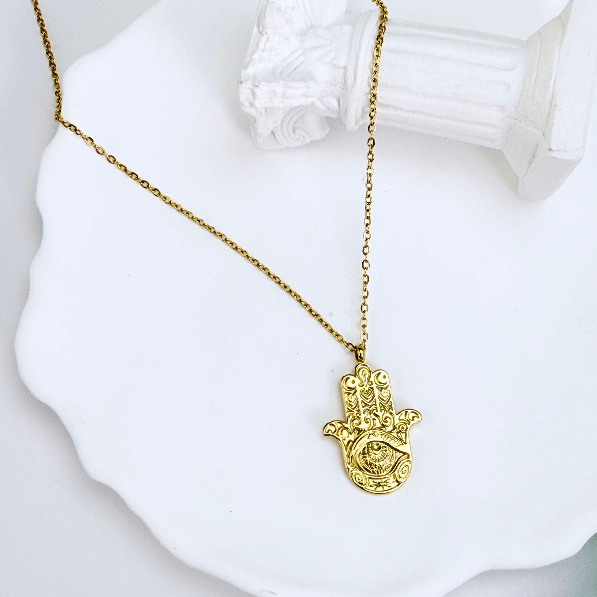 Gold Hamsa hand pendant necklace with engraved eye on a fine chain