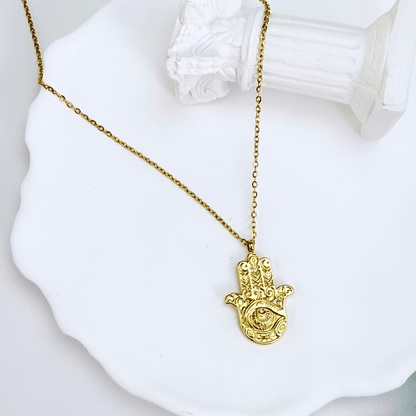 Gold Hamsa hand pendant necklace with engraved eye on a fine chain