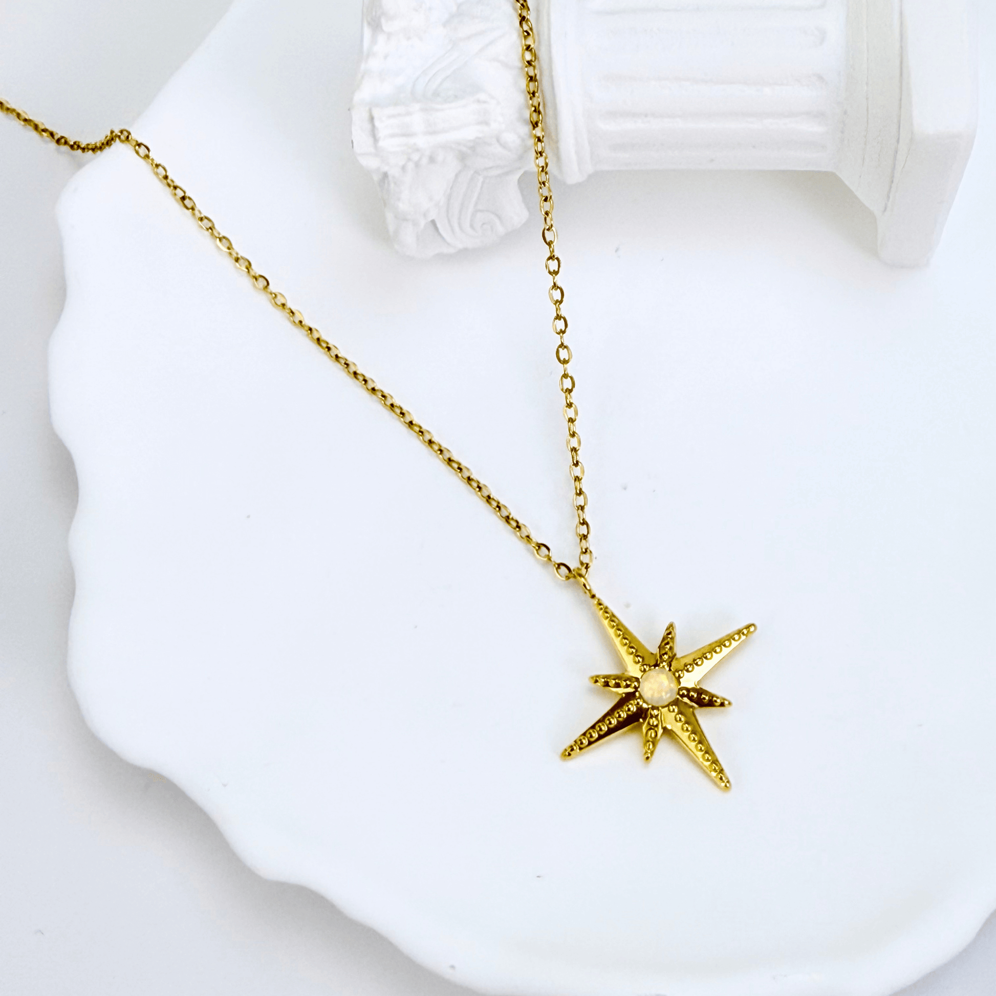 Gold North Star pendant necklace with luminous glass centre, symbolising guidance, balance, and hope.