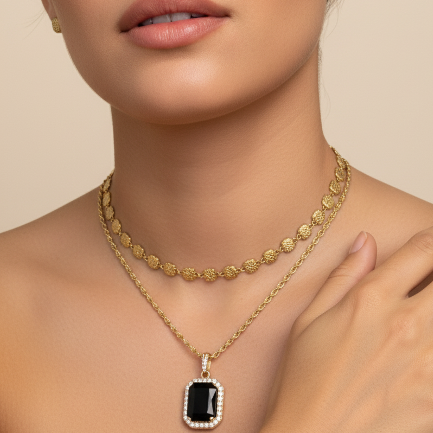 Gold onyx halo necklace with rectangular black zircon pendant and crystal halo on gold rope chain.