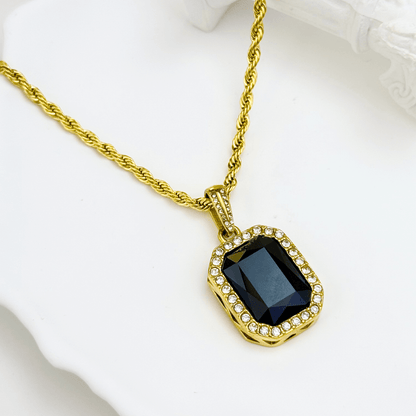 Gold onyx halo necklace with rectangular black zircon pendant and crystal halo on gold rope chain.