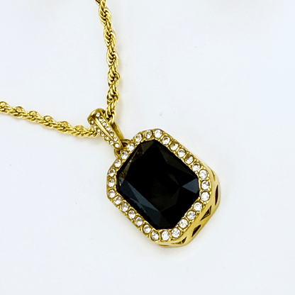 Gold onyx halo necklace with rectangular black zircon pendant and crystal halo on gold rope chain.