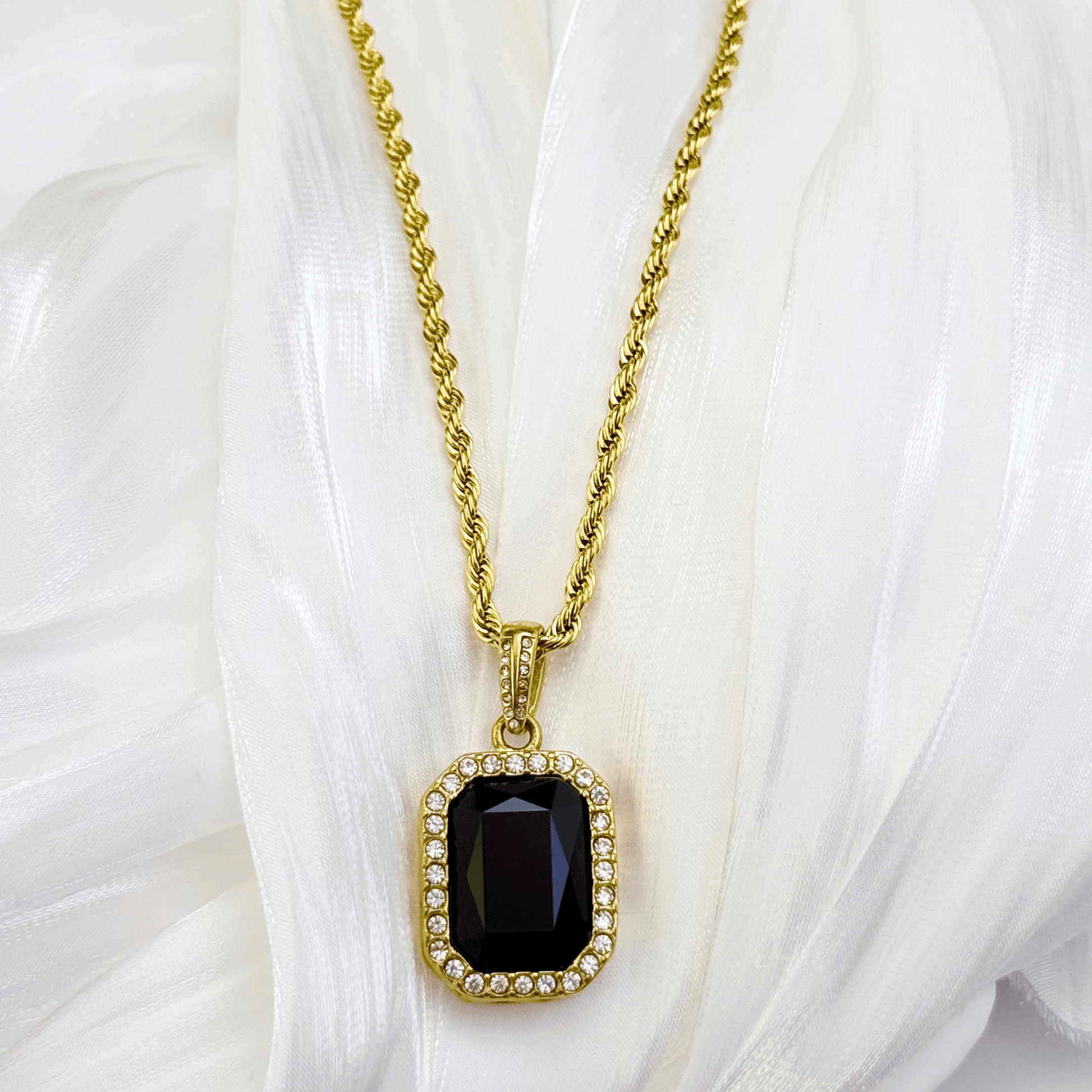 Gold onyx halo necklace with rectangular black zircon pendant and crystal halo on gold rope chain.