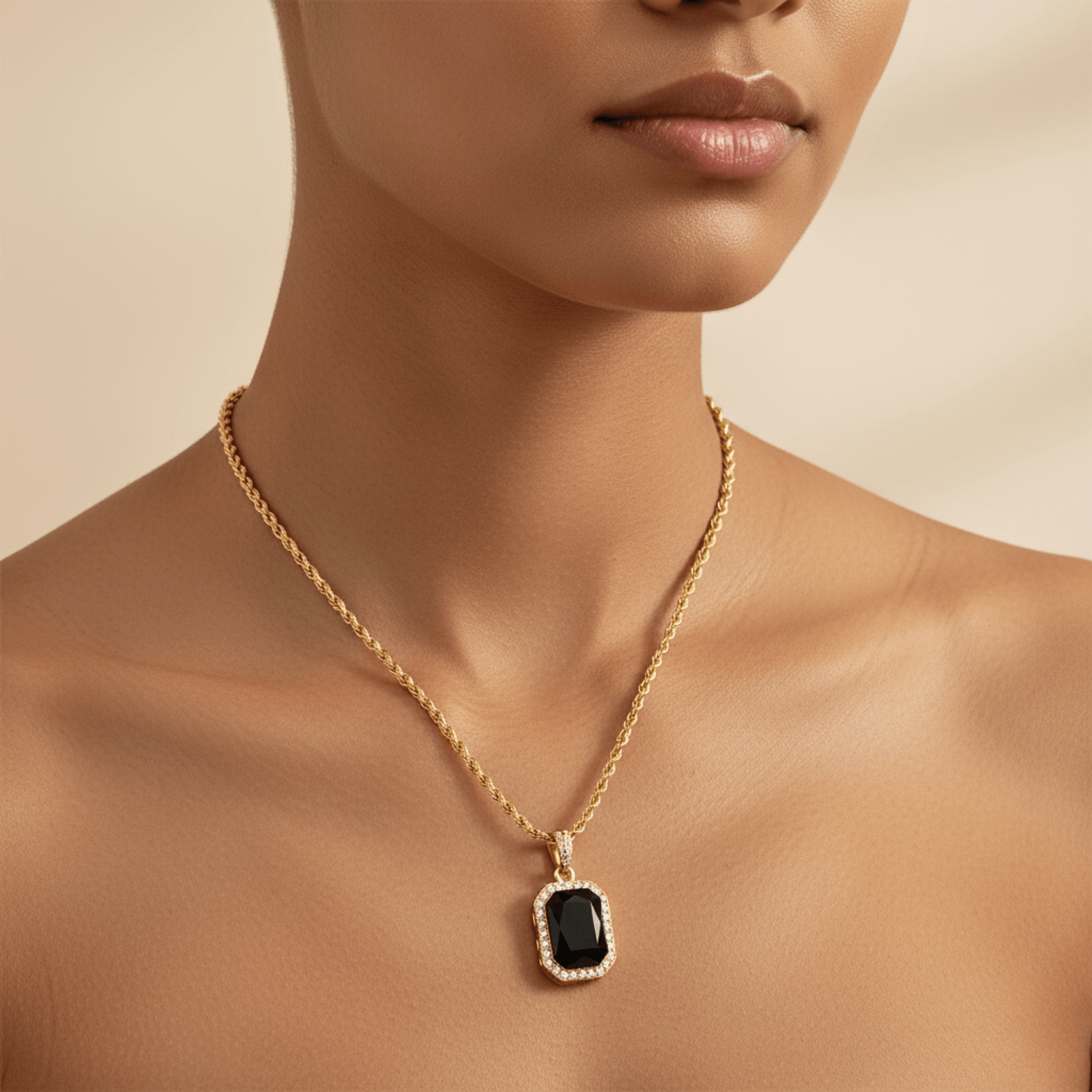 Gold onyx halo necklace with rectangular black zircon pendant and crystal halo on gold rope chain.