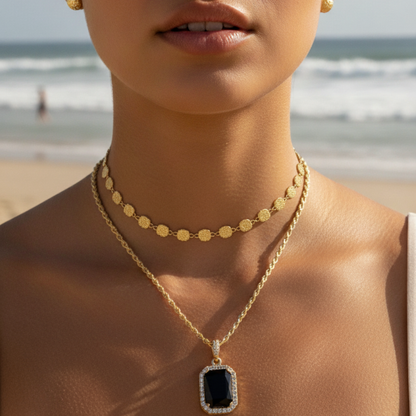Gold onyx halo necklace with rectangular black zircon pendant and crystal halo on gold rope chain.