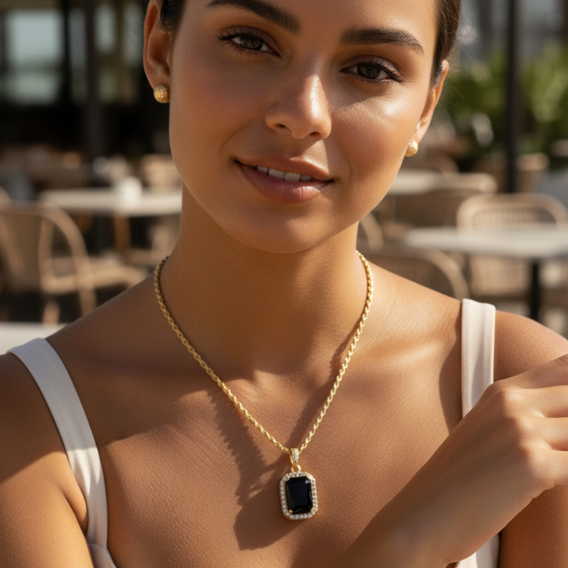 Gold onyx halo necklace with rectangular black zircon pendant and crystal halo on gold rope chain.