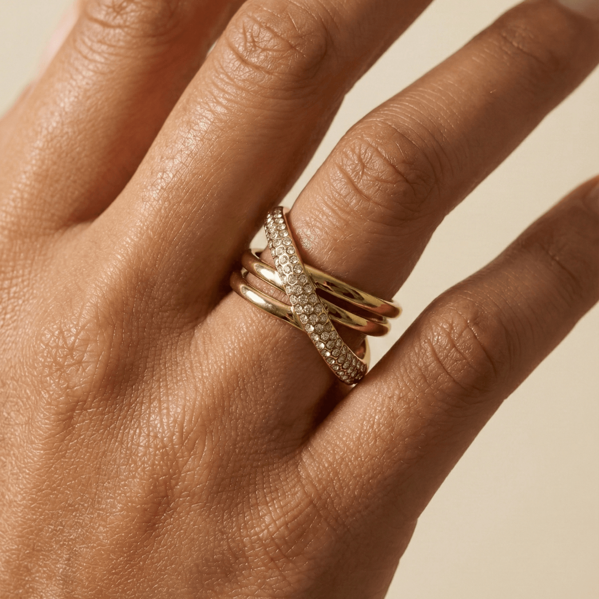 Gold Pave Crossover Ring by MXW Jewellery featuring intertwined gold bands and sparkling crystal pave details.