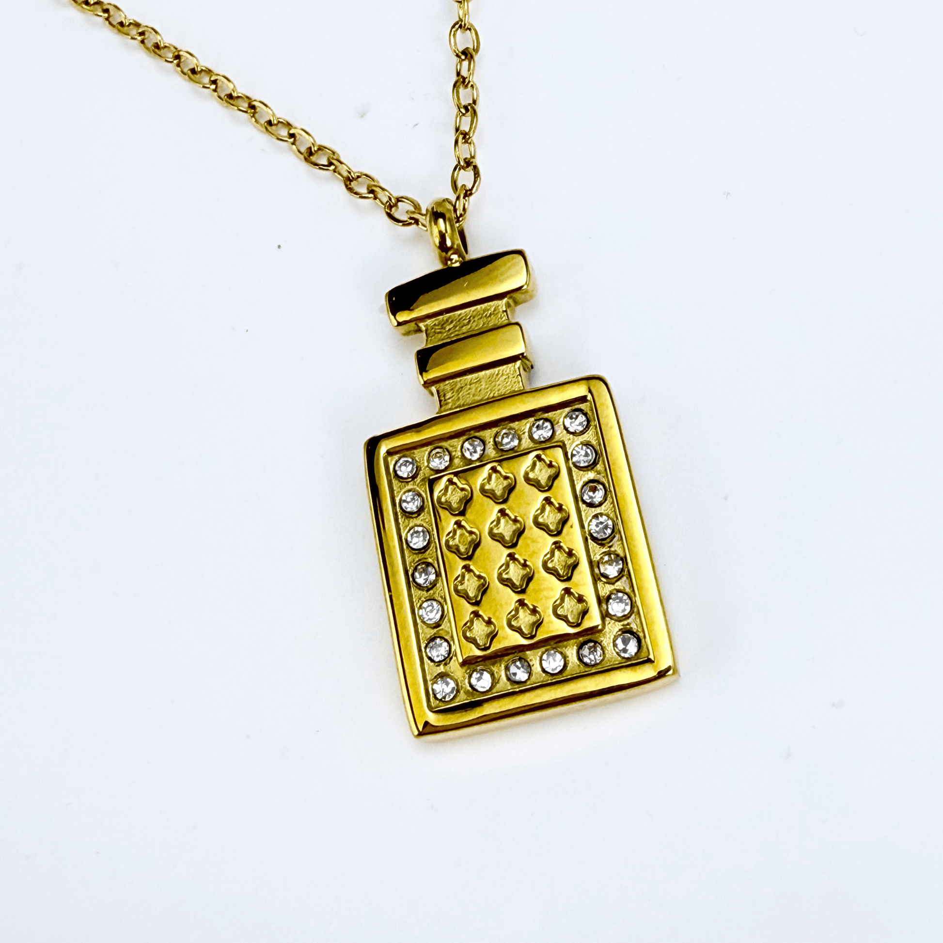 Gold perfume bottle pendant necklace with crystal detailing, symbolising elegance and charm.