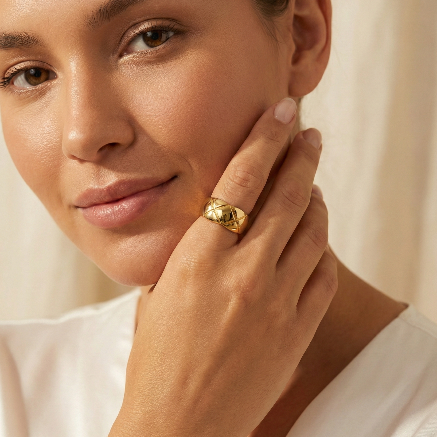 Quilted Gold Band Ring by MXW Jewellery, featuring a wide gold band with a geometric cross-hatch pattern on a white pedestal.