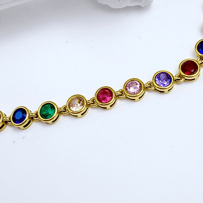 Gold rainbow crystal tennis bracelet with multi-coloured bezel-set stones.