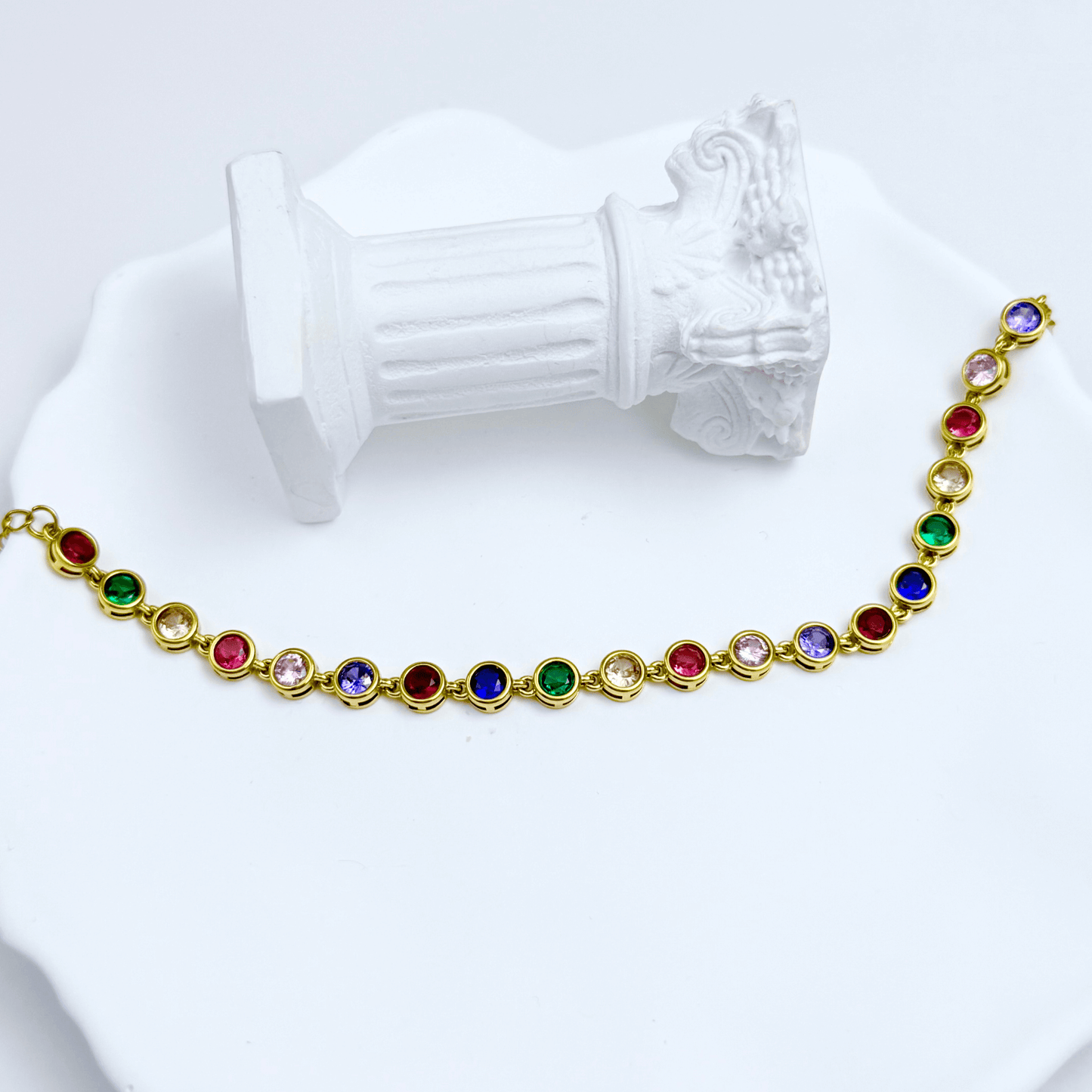 Gold rainbow crystal tennis bracelet with multi-coloured bezel-set stones.