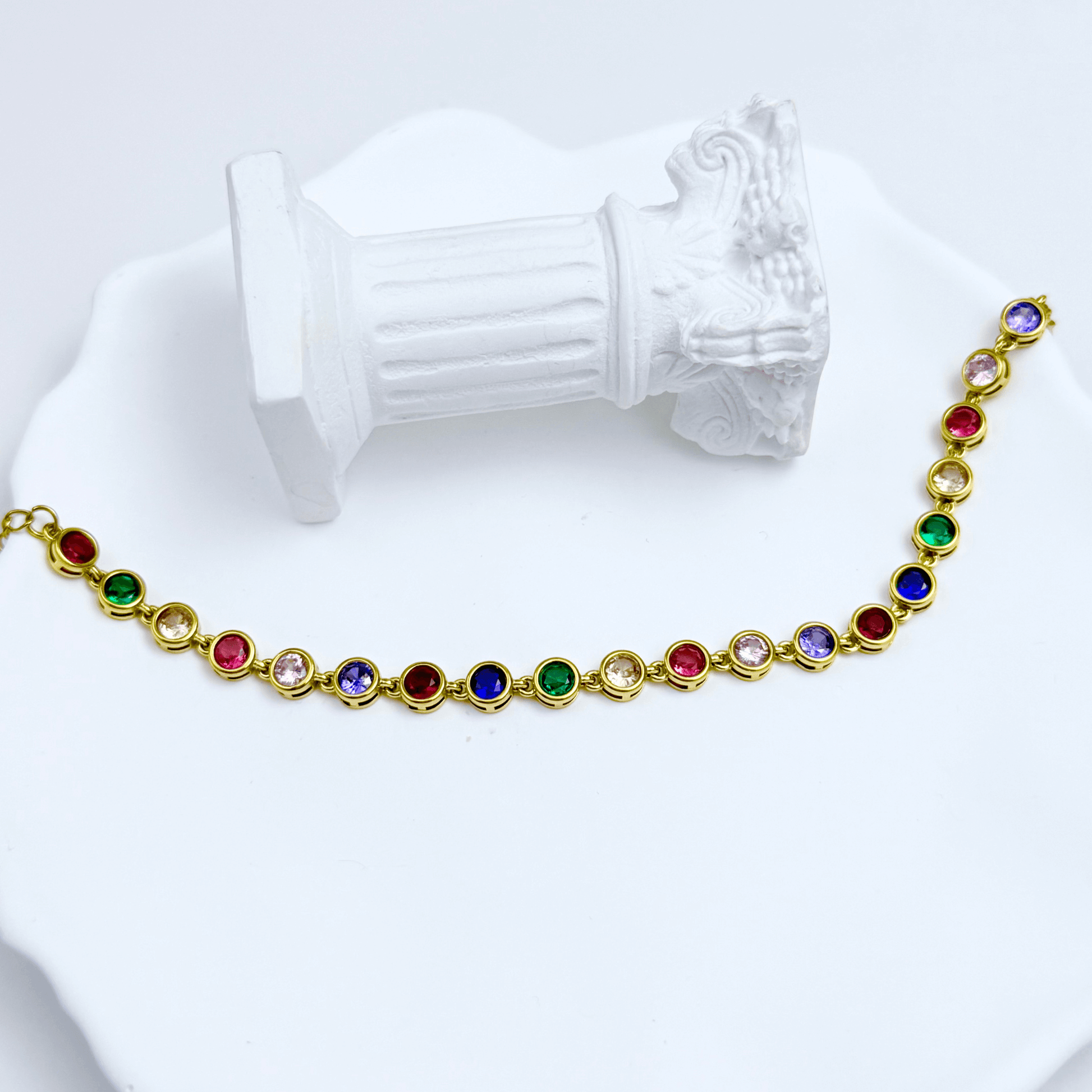 Gold rainbow crystal tennis bracelet with multi-coloured bezel-set stones.