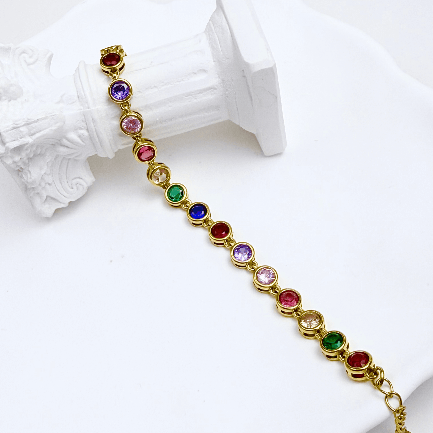 Gold rainbow crystal tennis bracelet with multi-coloured bezel-set stones.