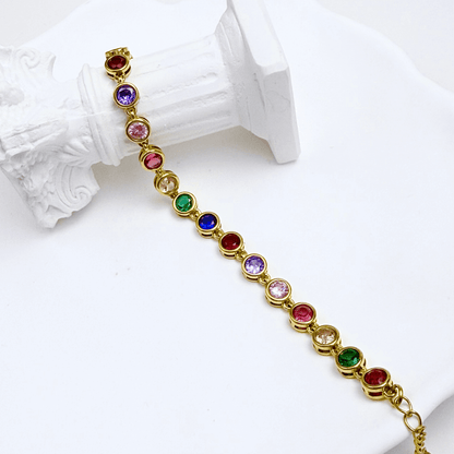 Gold rainbow crystal tennis bracelet with multi-coloured bezel-set stones.