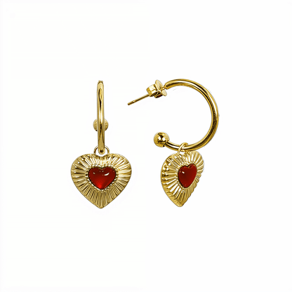 Gold hoop earrings featuring a textured heart charm with a red agate stone centre