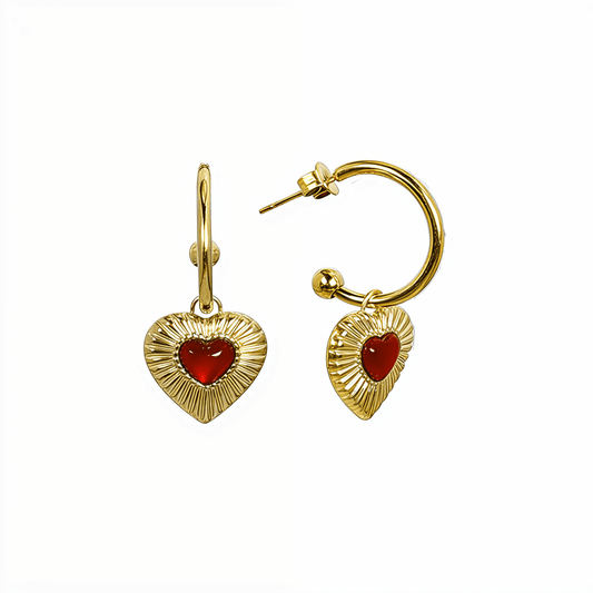Gold hoop earrings featuring a textured heart charm with a red agate stone centre