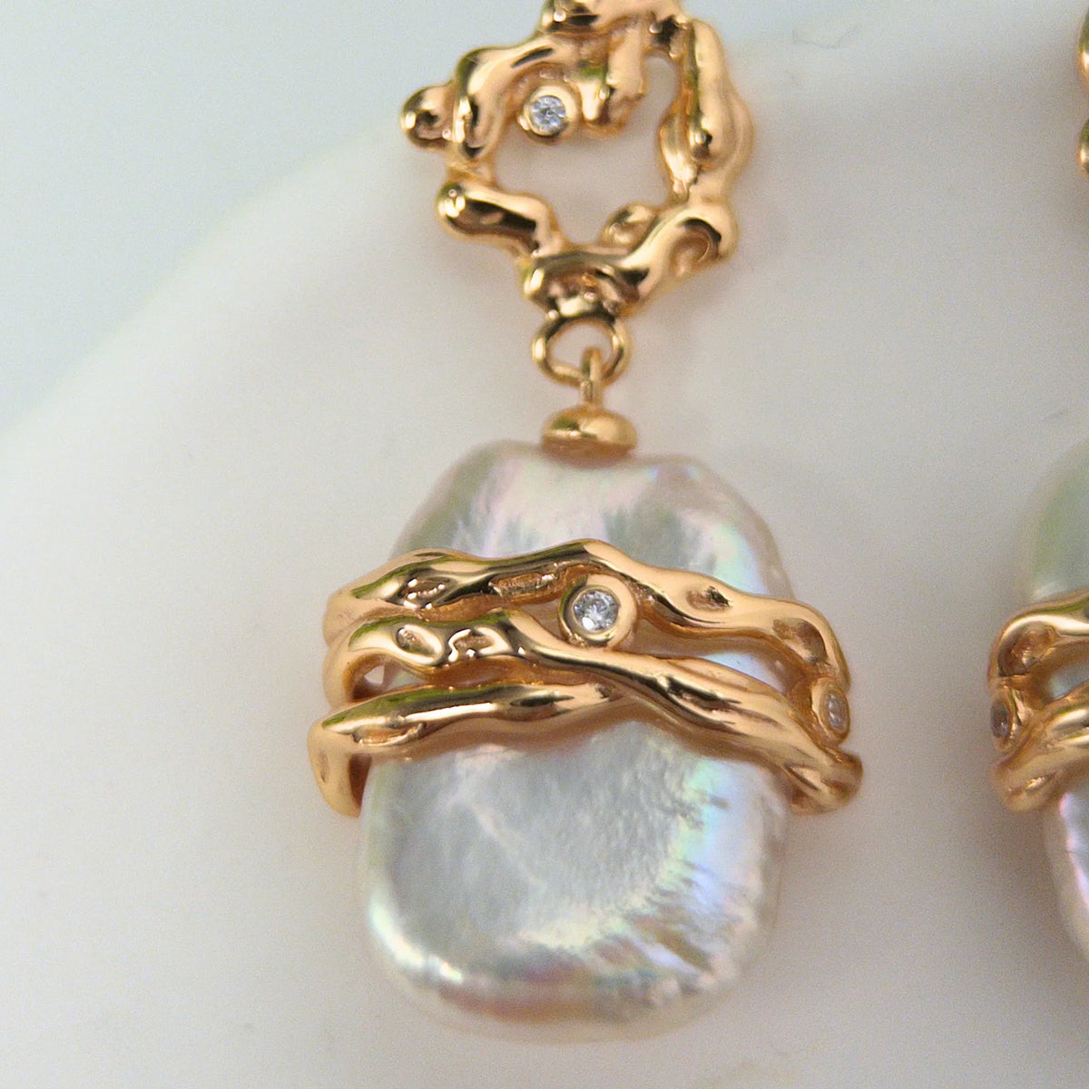 MXW Jewellery Gold vermeil drop earrings with a large baroque freshwater pearl wrapped in textured gold bands below an open molten stud