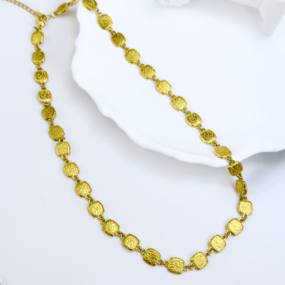 Gold textured square link chain necklace featuring small engraved square links connected in a continuous gold pattern.