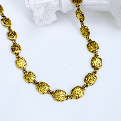 Gold textured square link chain necklace featuring small engraved square links connected in a continuous gold pattern.