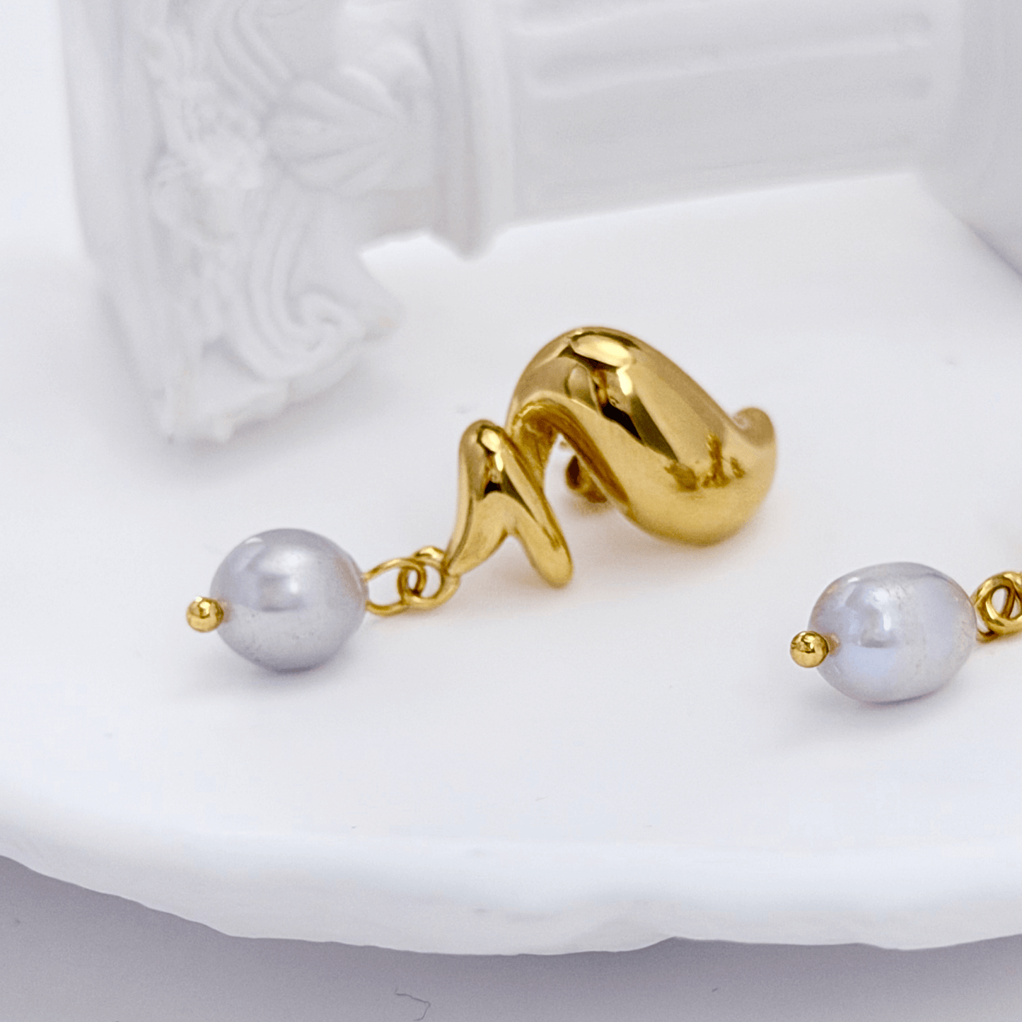 Gold twisted swirl pearl drop earrings displayed on a white bust, minimalist Australian design by MXW Jewellery