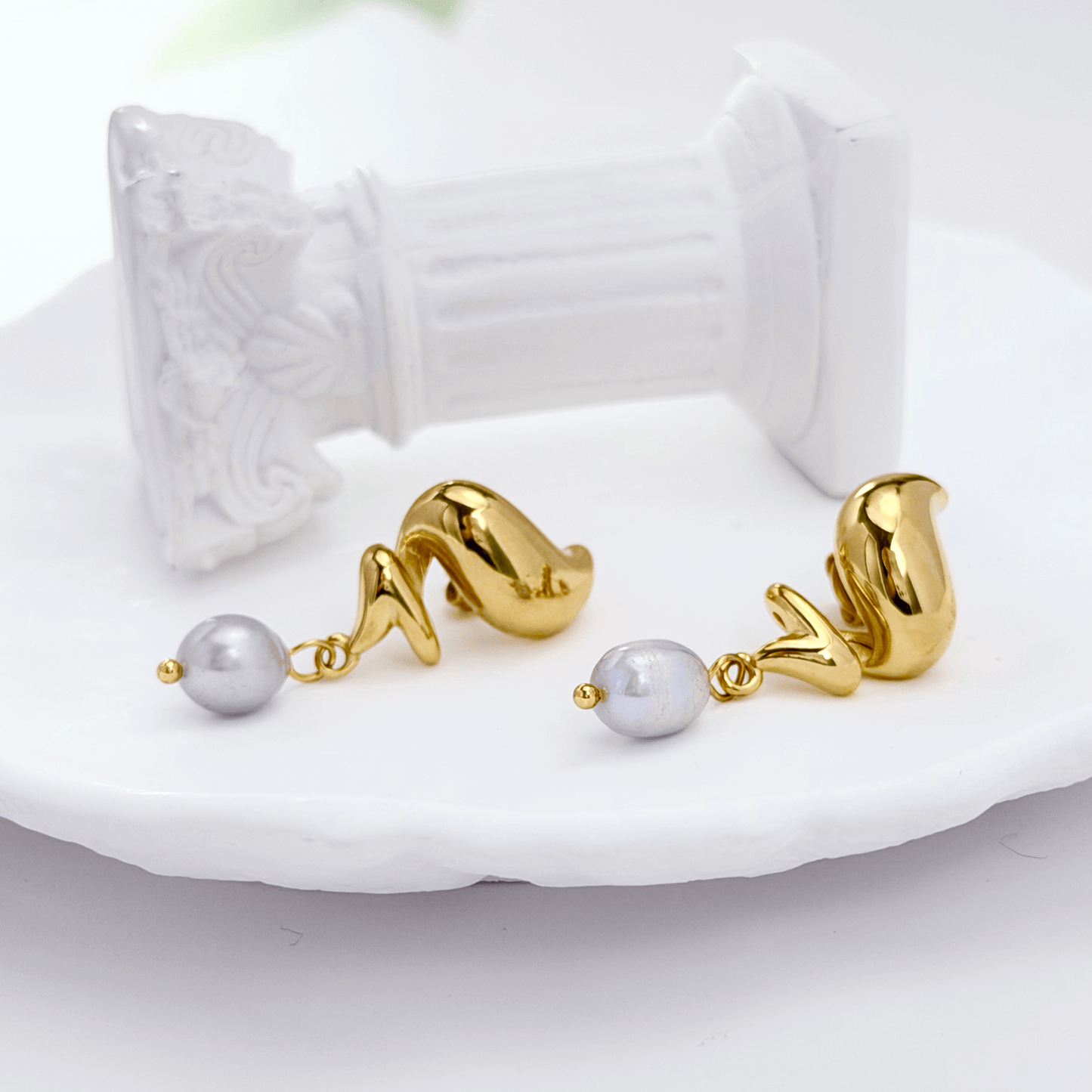 Gold twisted swirl pearl drop earrings displayed on a white bust, minimalist Australian design by MXW Jewellery
