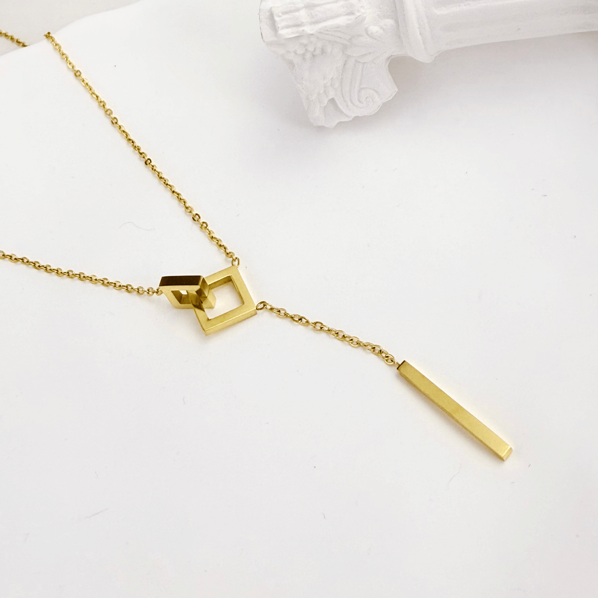 gold unity link necklace with interlocking geometric shapes symbolising connection and strength
