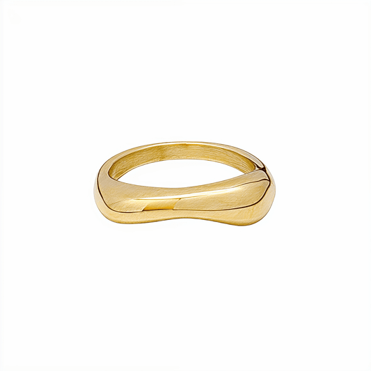 Gold Wave Ring by MXW Jewellery featuring a sculptural fluid design and waterproof gold finish displayed on a white textured column