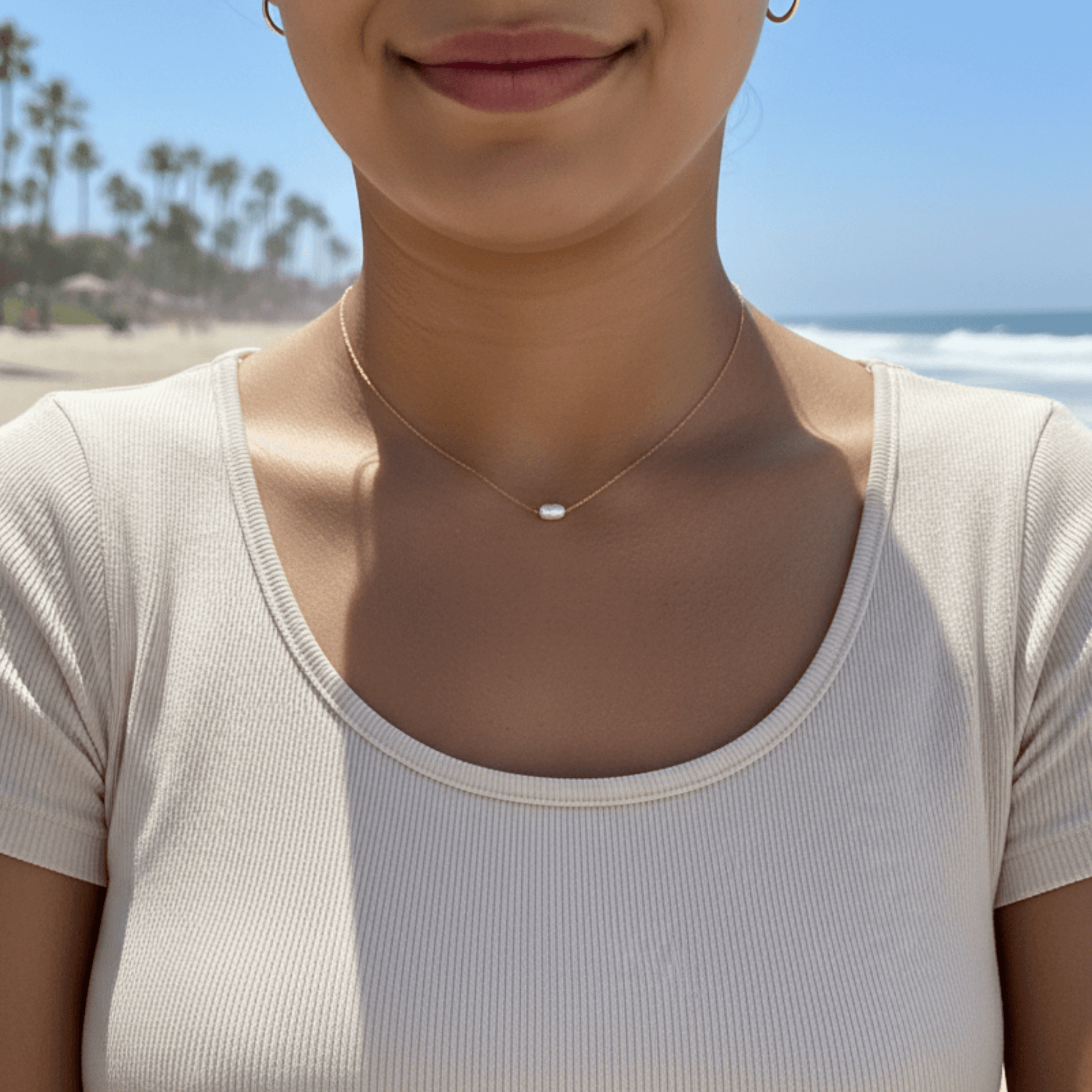 Dainty gold chain necklace with single freshwater pearl, minimalist waterproof design for layering or everyday wear.