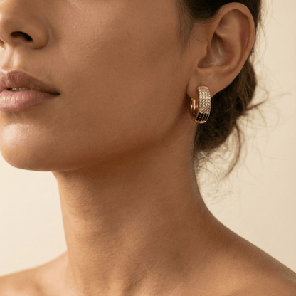 Gradient black pavé gold huggie earrings with ombré crystals.