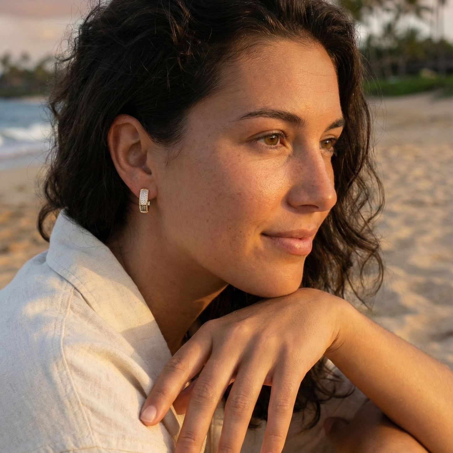 Gradient black pavé gold huggie earrings with ombré crystals.