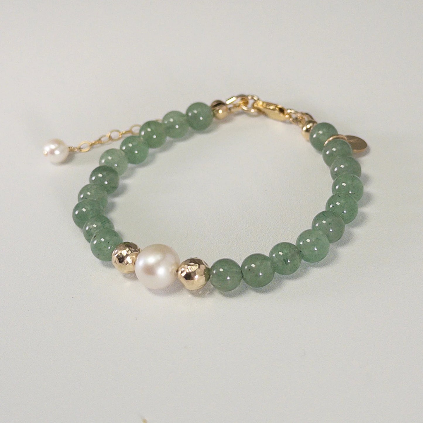 Green aventurine, pearl and initial gold bracelet featuring polished green gemstone beads, lustrous freshwater pearls and a personalised gold-filled stamped initial disc.