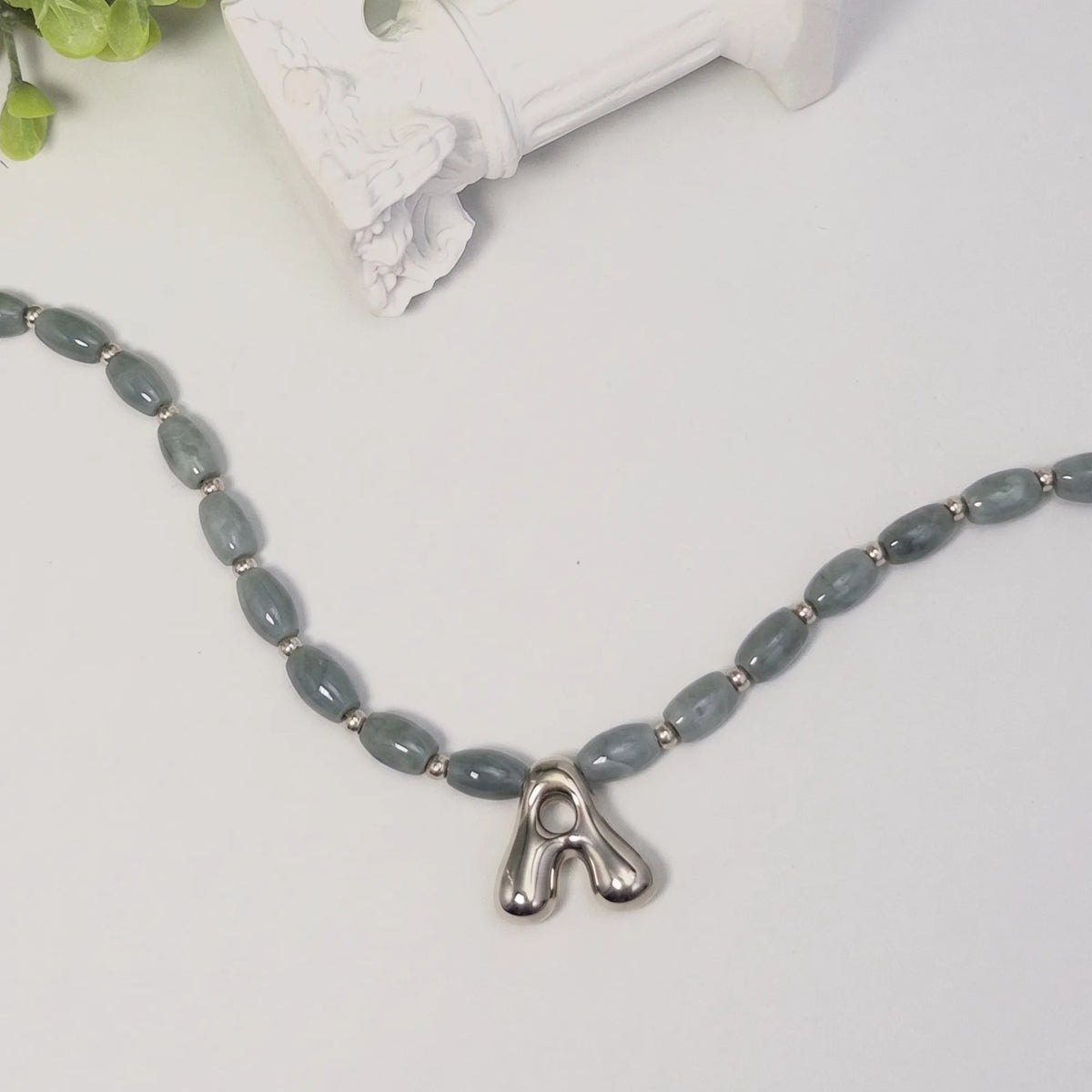 Guatemalan jade initial necklace with smooth barrel beads, sterling silver spacers and a bubble letter pendant