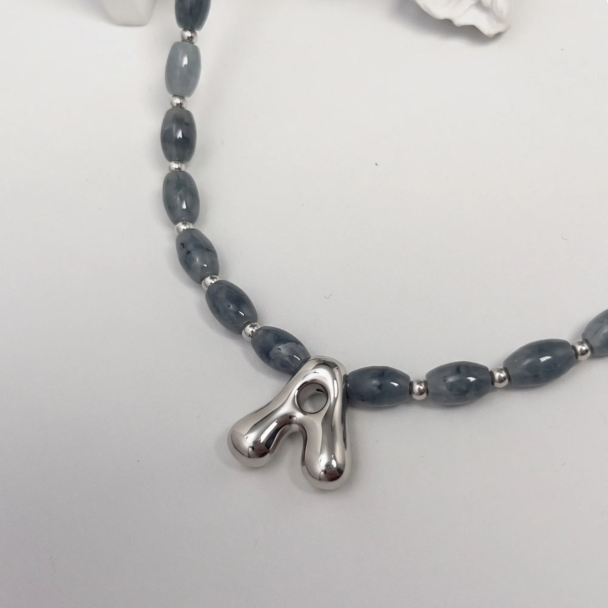 Guatemalan jade initial necklace with smooth barrel beads, sterling silver spacers and a bubble letter pendant