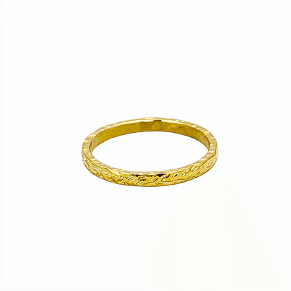 Minimal hammered slim gold ring with organic texture on a clean background.