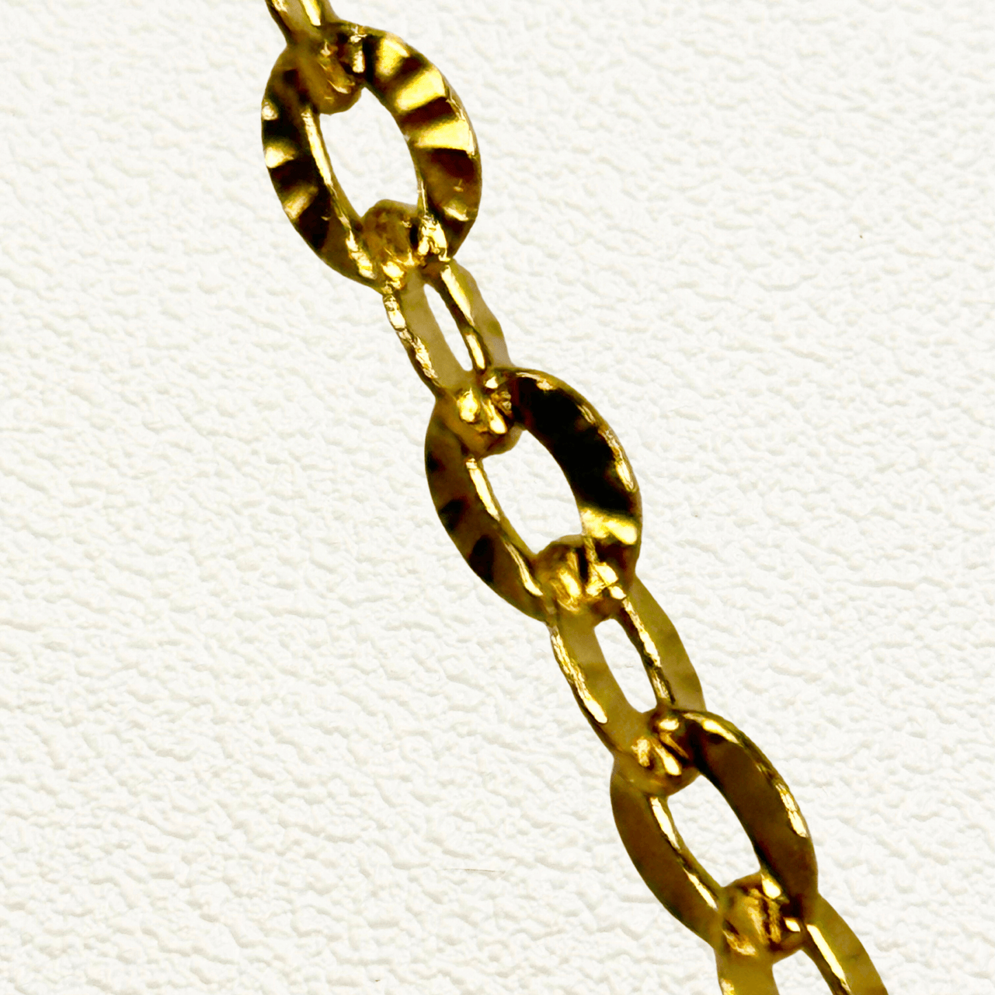 Hammered gold link chain with textured oval embossed links in waterproof stainless steel.