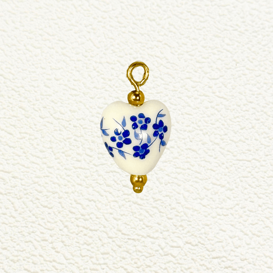Heart-shaped ceramic charm with small blue flowers and gold bead details