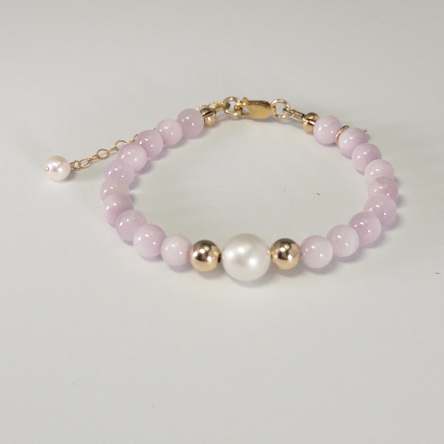 Kunzite, pearl and initial gold bracelet featuring translucent violet kunzite beads, lustrous freshwater pearls and a personalised gold-filled stamped initial disc.