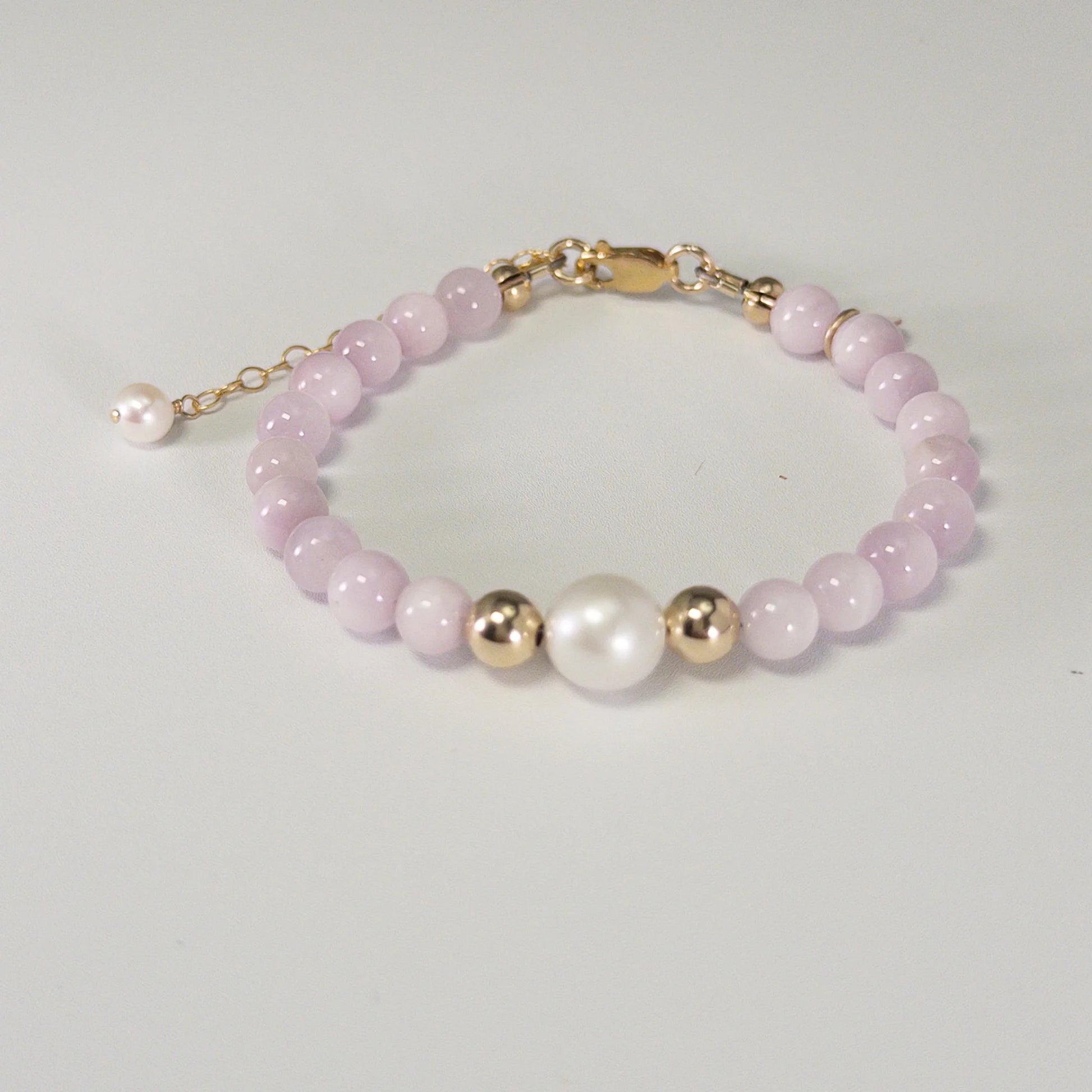 Kunzite, pearl and initial gold bracelet featuring translucent violet kunzite beads, lustrous freshwater pearls and a personalised gold-filled stamped initial disc.