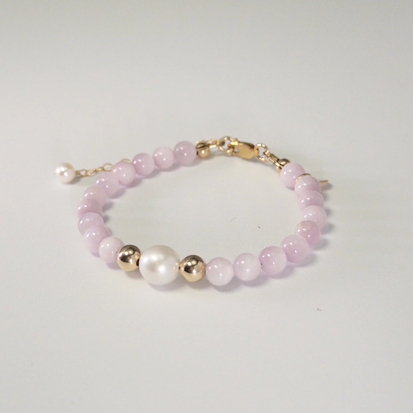 Kunzite, pearl and initial gold bracelet featuring translucent violet kunzite beads, lustrous freshwater pearls and a personalised gold-filled stamped initial disc.