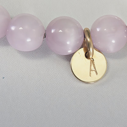 Kunzite, pearl and initial gold bracelet featuring translucent violet kunzite beads, lustrous freshwater pearls and a personalised gold-filled stamped initial disc.