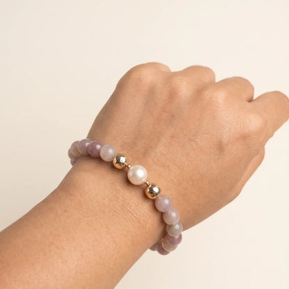 A beaded bracelet featuring mauve rose quartz, premium freshwater pearl, and stamped initial disc. 14k gold filled. MXW Jewellery