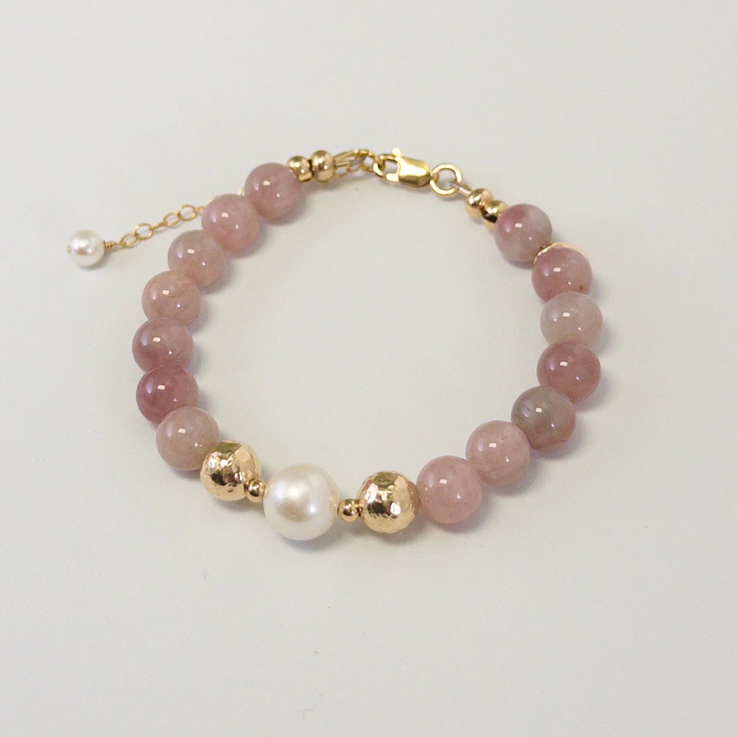 A beaded bracelet featuring mauve rose quartz, premium freshwater pearl, and stamped initial disc. 14k gold filled. MXW Jewellery