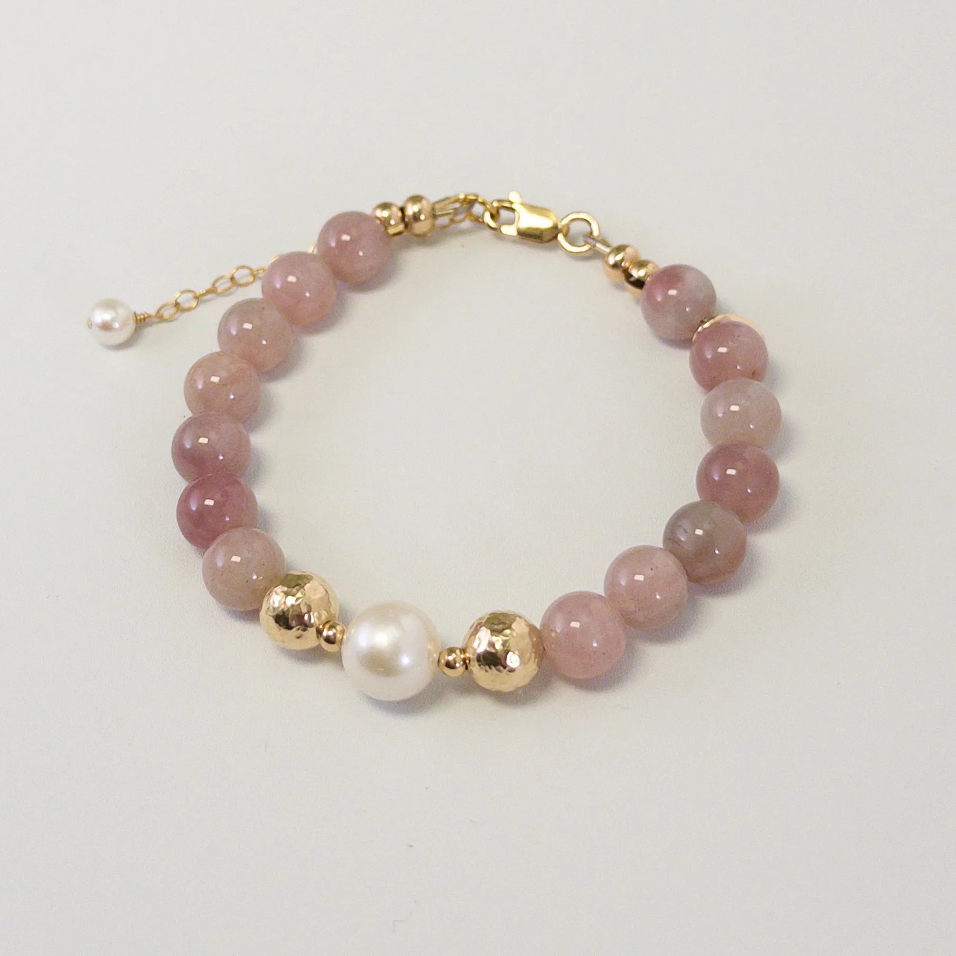 A beaded bracelet featuring mauve rose quartz, premium freshwater pearl, and stamped initial disc. 14k gold filled. MXW Jewellery