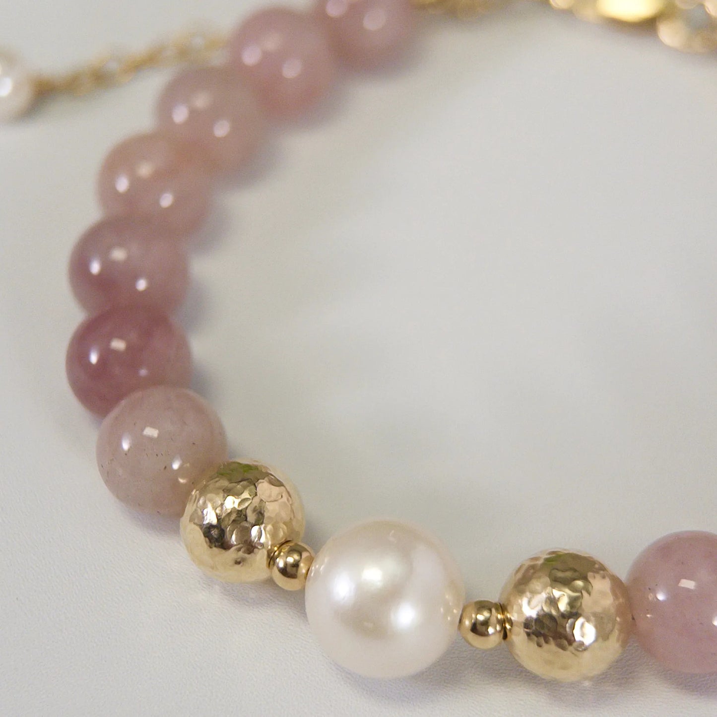 A beaded bracelet featuring mauve rose quartz, premium freshwater pearl, and stamped initial disc. 14k gold filled. MXW Jewellery