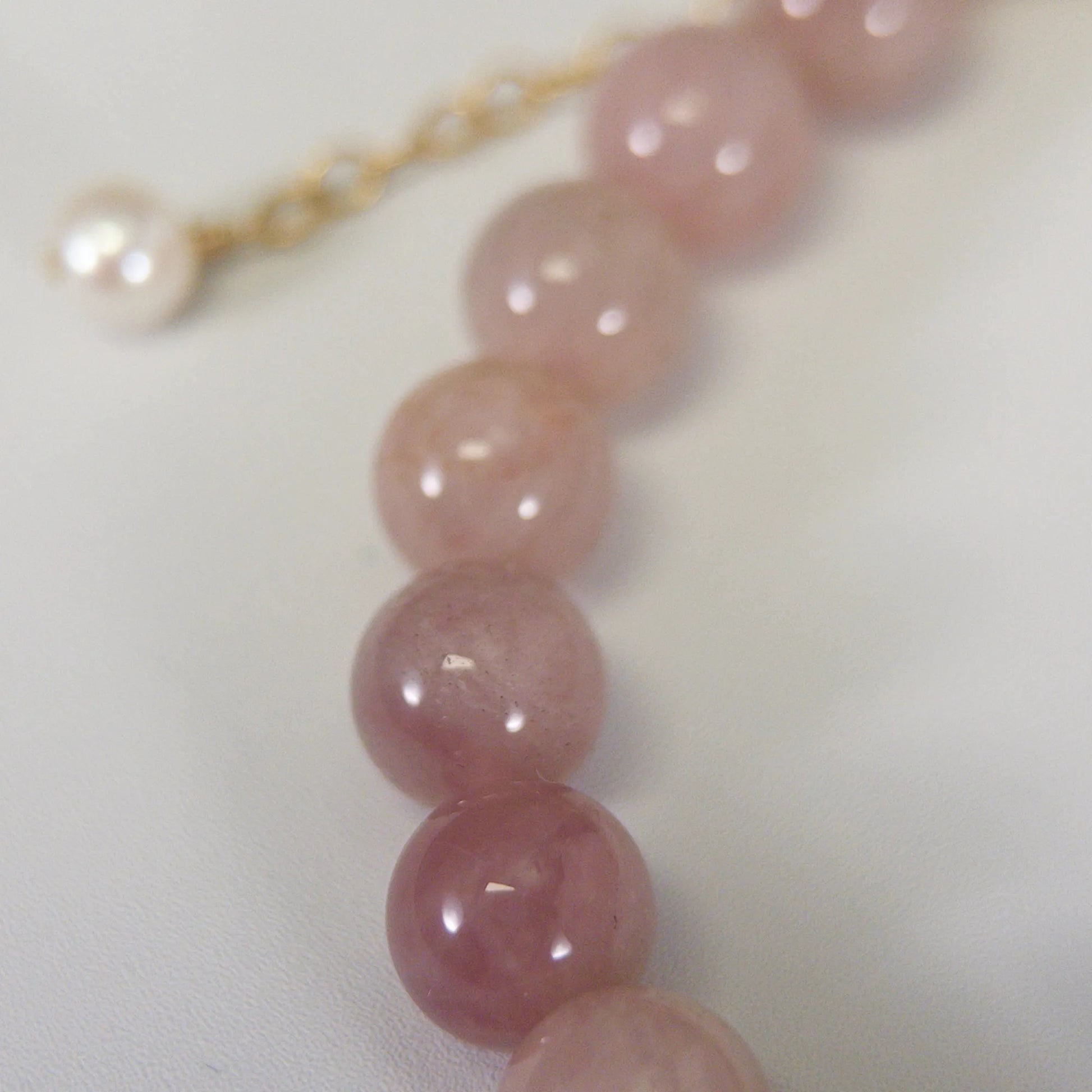 A beaded bracelet featuring mauve rose quartz, premium freshwater pearl, and stamped initial disc. 14k gold filled. MXW Jewellery